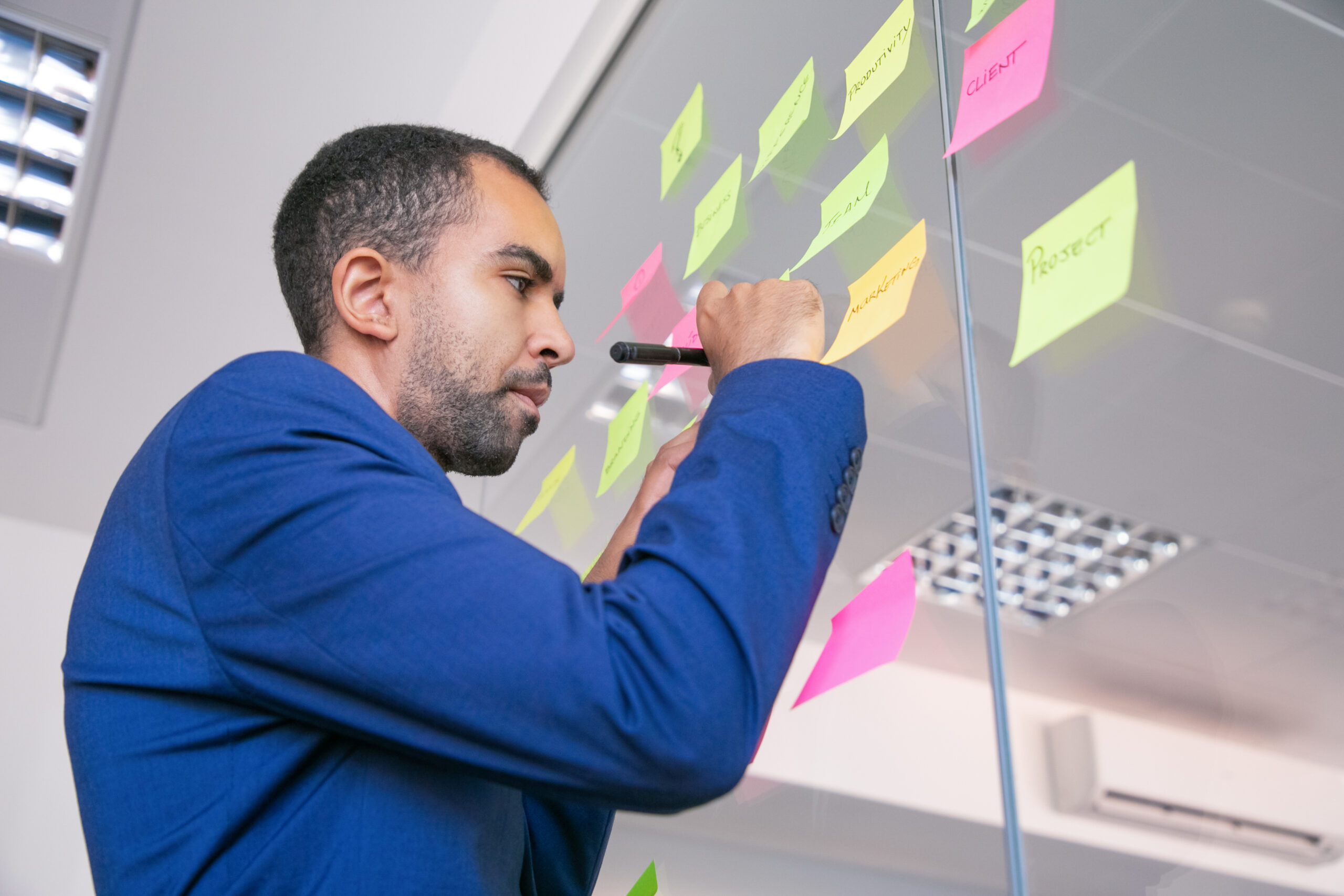african american office employer writing on sticker with marker