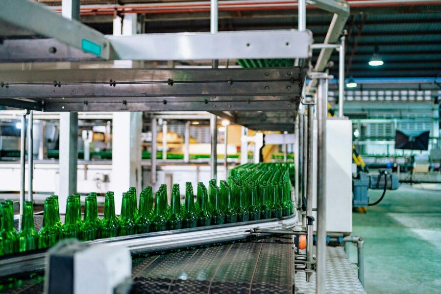 Streamlined glass bottle manufacturing process in factory setting, showcasing assembly line automation.